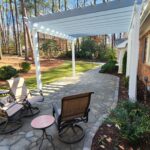 Brick house with a white pergola over a stone patio