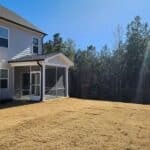 Two-story beige house with a screened back porch, before.