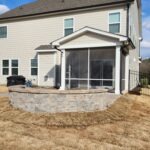 Rear view of beige two-story house and patio